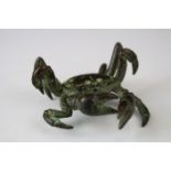 A bronze crab with large claws, approx 4cm in height.