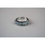 A silver and aquamarine seven stone ring.