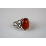 A silver ring with large amber style cabochon.