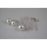 A pair of silver freshwater pearl stud earrings with matching necklace.
