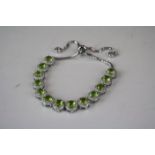 A silver CZ and peridot bracelet with size adjuster.