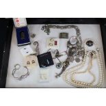 A small collection of jewellery to include silver examples contained within a glass topped display