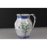 A late 20th century studio pottery jug decorated with stylised trees and leaping stag, signed with