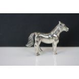 A silver cast figure of a horse.