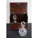 A pair of cut glass decanters within a hinged mahogany case.