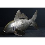 A large white metal ornamental articulated fish.