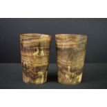 A pair of antique carved horn beakers with bevelled glass bottoms.