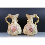 Pair of Royal Worcester Blush Ivory Jugs, decorated with flowers and with gilt moulded handles in