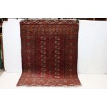 Eastern Red Ground Wool Bokhara Rug, the centre with row of nine geometric diamonds flanked by two