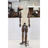 Female Shop Mannequin with cloth covered head and body, wooden articulated arms and legs, mounted on