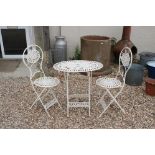 A white painted wrought iron garden table and chair set.