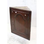 George III Oak Hanging Corner Cabinet, the single door opening to two shelves, 64cm wide x 78cm high