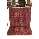 Eastern Red Ground Bokhara Rug, the centre with four row of twelve Guls within a border of geometric