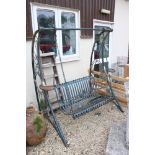 A large wrought iron garden two seater swing bench.