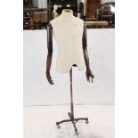 Male Shop Mannequin with cloth covered torso and articulated wooden arms, mounted on an industrial