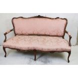French Louis XV style Carved Walnut Settee with pink upholstery raised on five carved cabriole legs,