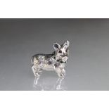 Silver figure of a dog with emerald collar