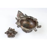 A south East Asian figural ashtray set with semi precious stones together with a bronze pill press.