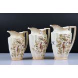 Set of Three Crown Ducal Graduating Blush Ivory Jugs decorated with exotic birds, largest 22cm