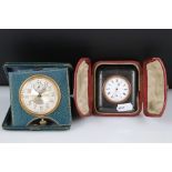 Two early 20th century travel clocks both complete with original fitted cases.