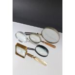 A small collection of five magnifying glasses.