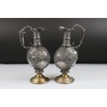 Pair of Renaissance style Pewter covered Glass Claret Jugs raised on brass circular bases, 36cm high