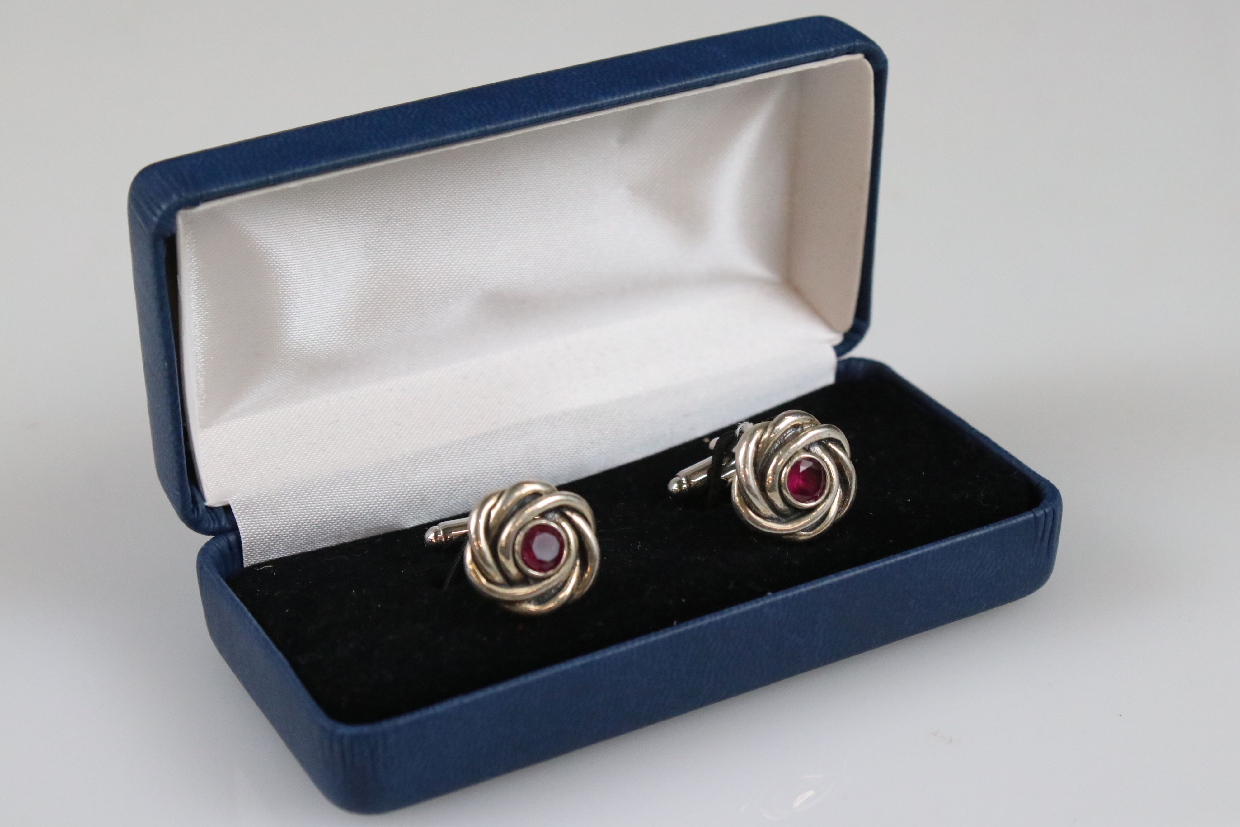 Two cased sets of cufflinks, one in the form of knots with Rubilite centre panel