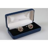 Two cased sets of cufflinks, one in the form of knots with Rubilite centre panel