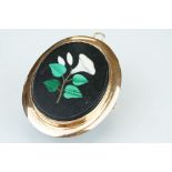Pietra dura rose metal brooch, the oval panel set with floral design, rubover set, plain polished