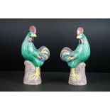 Pair of Chinese porcelain polychrome decorated cockerels, each raised upon a naturalistic stump,