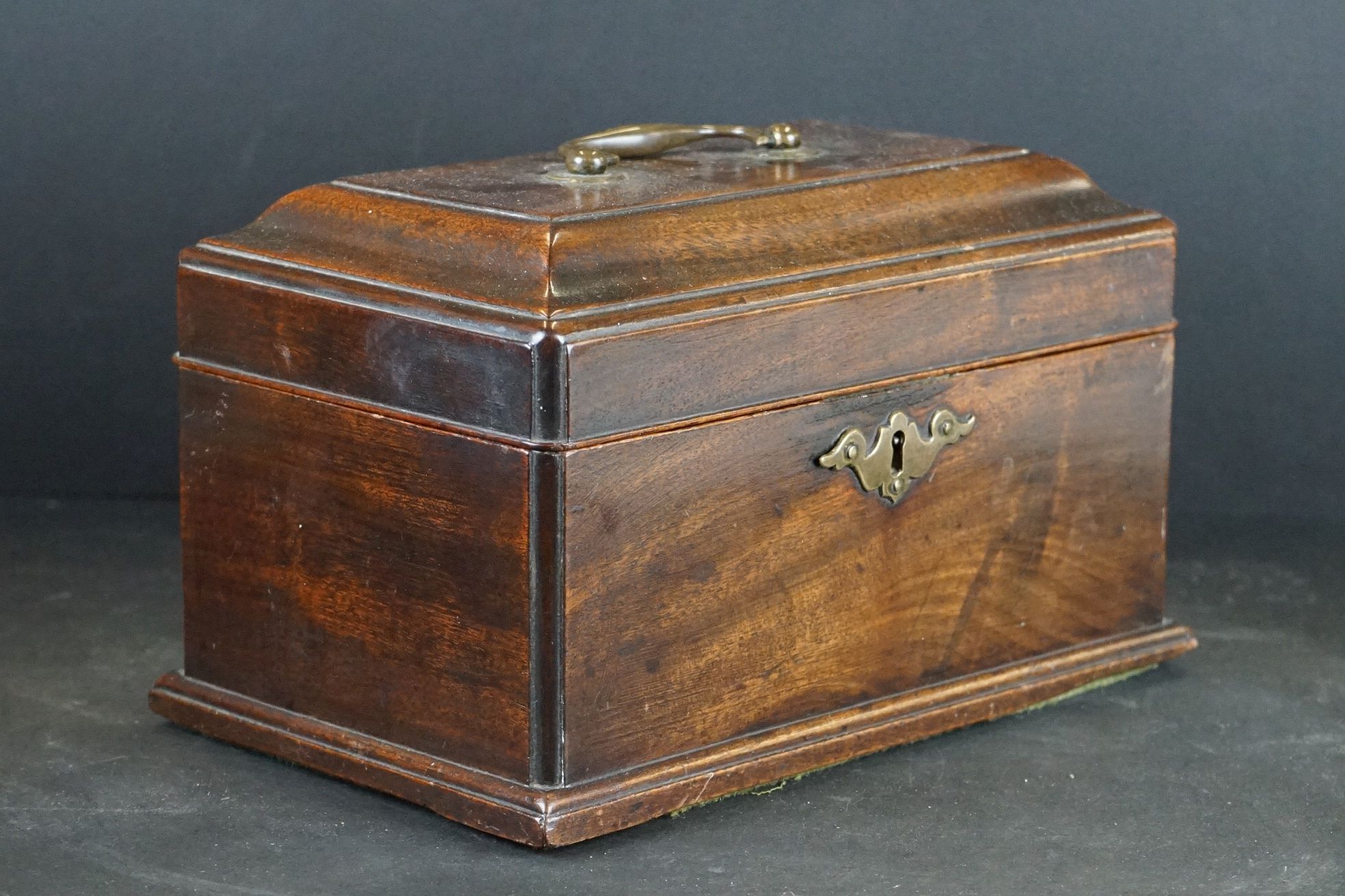 An antique wooden lidded box with brass fittings