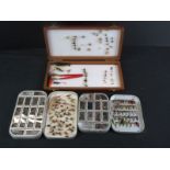 A collection of fishing flies contained within three boxes.