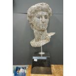 Sculpture of a male head, resembling Michelangelo's David, constructed from metal hexagonal nuts,