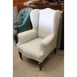 Late 19th / Early 20th century Wing Back Armchair upholstered in pale green fabric and raised on