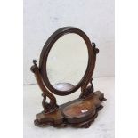 Victorian Mahogany Oval Swing Dressing Mirror held on a scrolling carved support and a shaped base