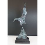 Contemporary bronze sculpture of a flying bird, with Verdigris finish, mounted on wooden stand,