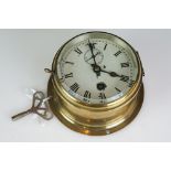 An early 20th Century Brass Cased Ships Bulkhead Type Key Wind Wall Clock, the drum-shaped case with