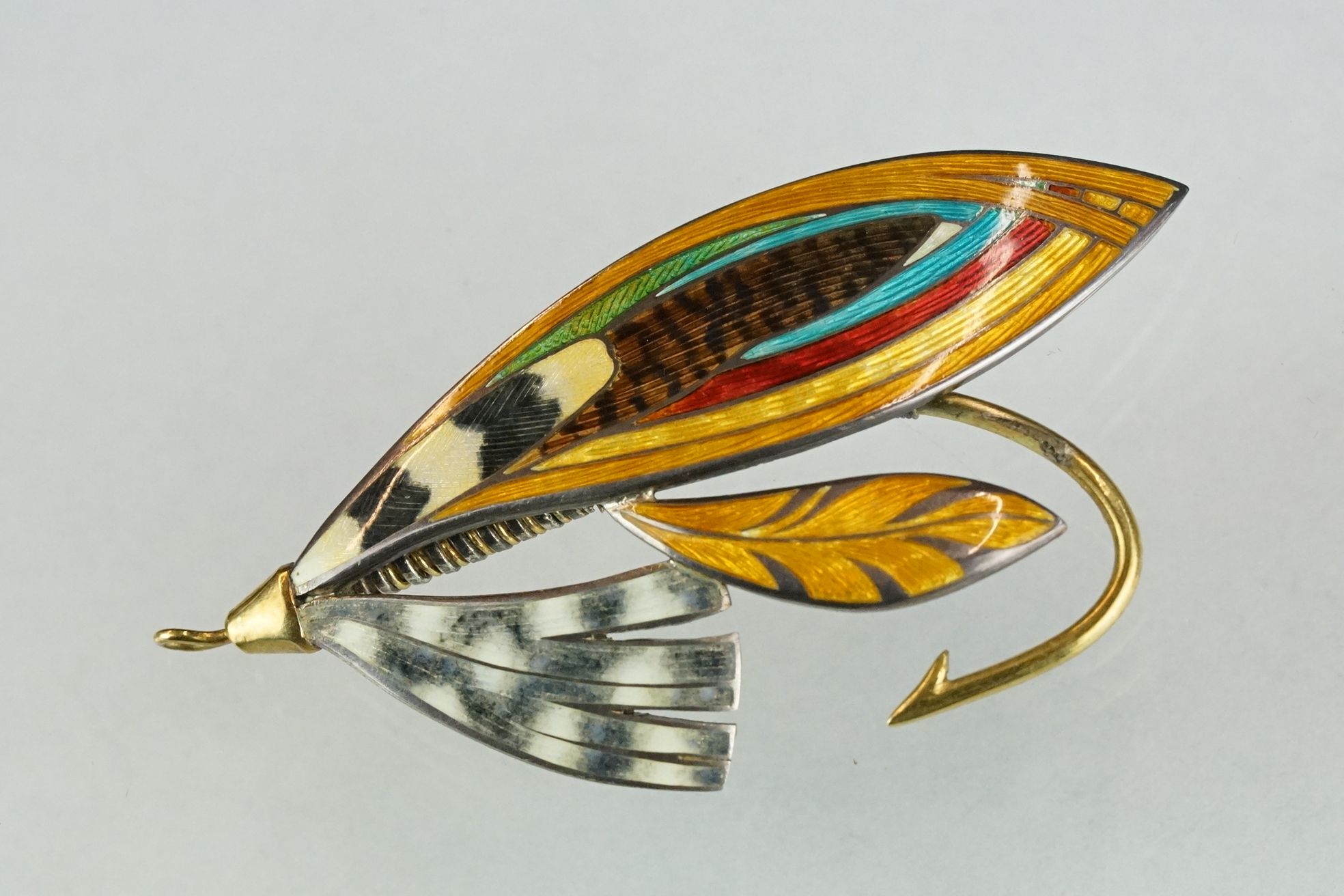 A fully hallmarked sterling silver and enamel brooch in the form of a fishing fly.