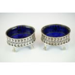 A pair of fully hallmarked sterling silver mustard pots complete with original blue cut glass