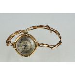 Early 20th century 9ct gold cased ladies wristwatch with yellow metal strap and silvered dial.