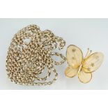 A white metal muff / guard chain together with a yellow metal butterfly brooch.