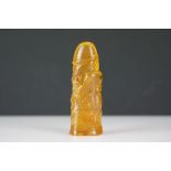 A carved amber Japanese Netsuke pendant in the form of a phallus
