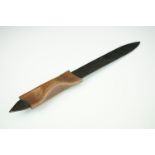A blackened metal paper knife with formed leather handle.