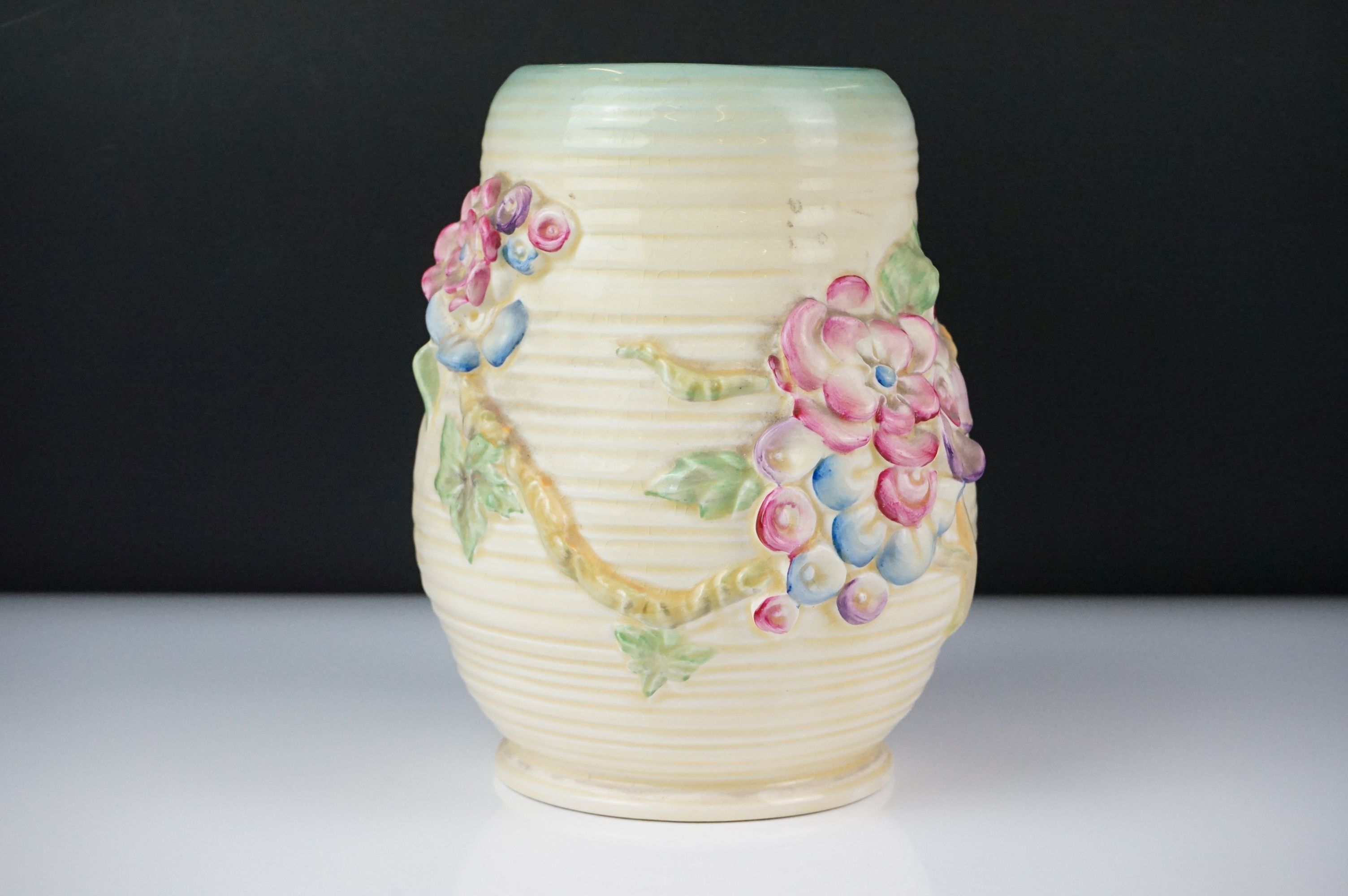 Clarice Cliff Newport Pottery vase of baluster form, with polychrome moulded blossom decoration on a