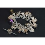 A hallmarked sterling silver charm bracelet complete with a good quantity of charms together with