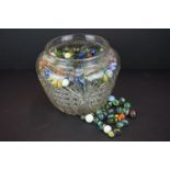 A large collection of mainly contemporary marbles contained within a glass jar.