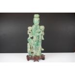 Chinese carved jade figure of Guanyin in robed dress, standing holding a flower, with a bird