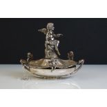 A Victorian silver plated table centrepiece with a winged cherub holding a butterfly above three