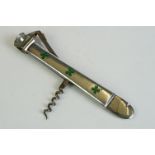 A Continental silver cigar cutter, enamelled with four leaf clovers, corkscrew, and wire cutter (