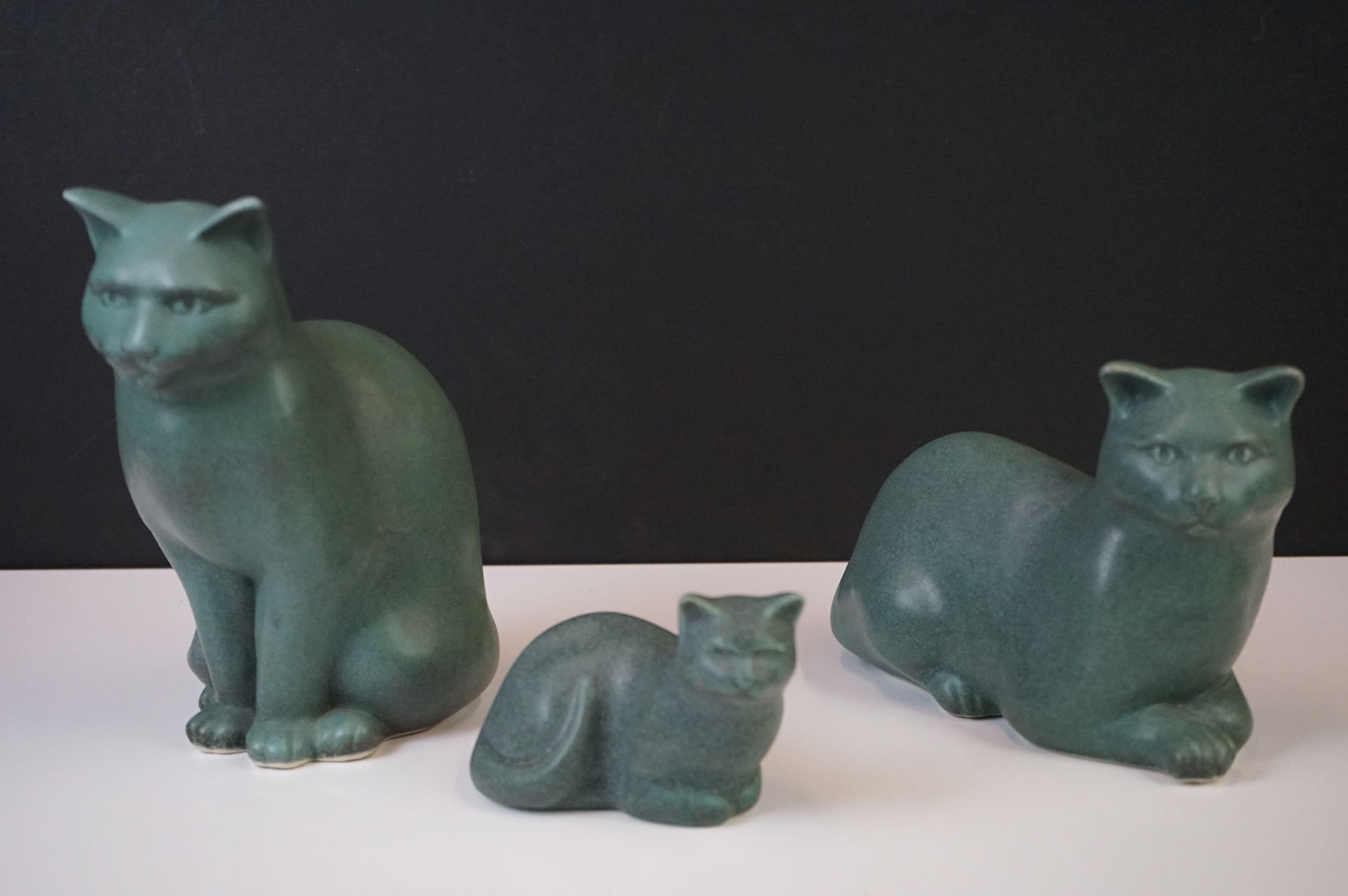 Three Moorside Design mottled turquoise ceramic models of seated cats, with original paper labels,